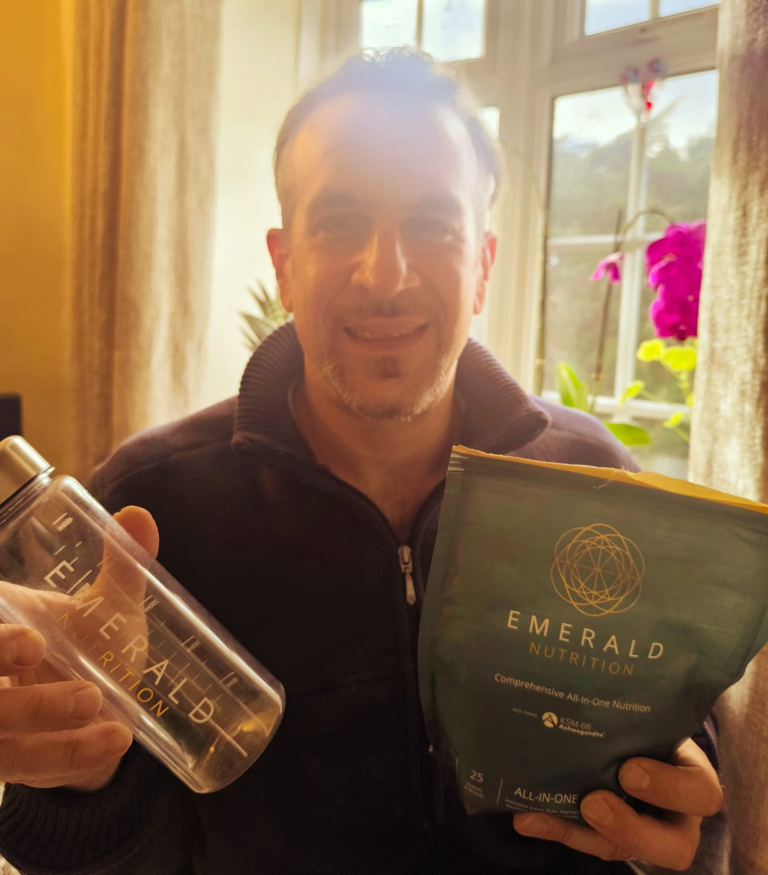 Man holding a pouch of Emerald and a bottle