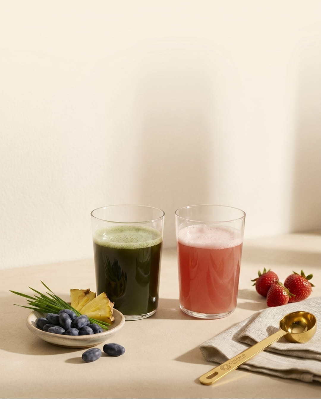 Emerald Nutrition Supergreens and Ignite drinks with fresh pineapple, haskap berries, strawberries and gold scoop on warm cream