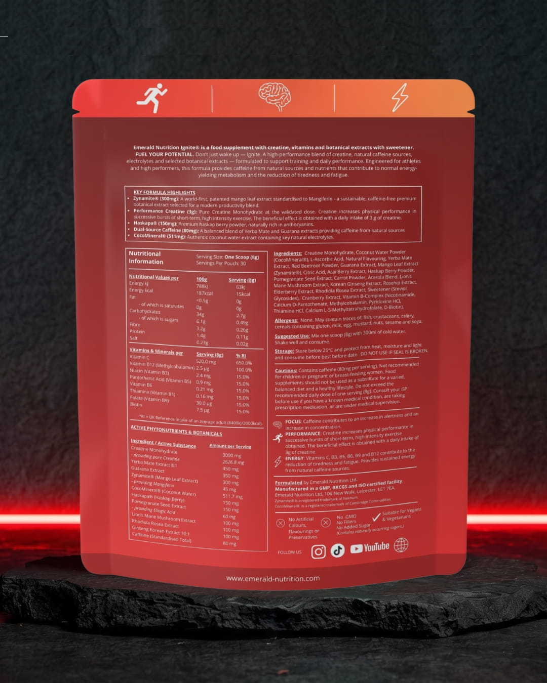 The back of a red stand-up pouch package, likely a protein powder or supplement bag, displayed upright on a dark stone surface with red light strips in the background.