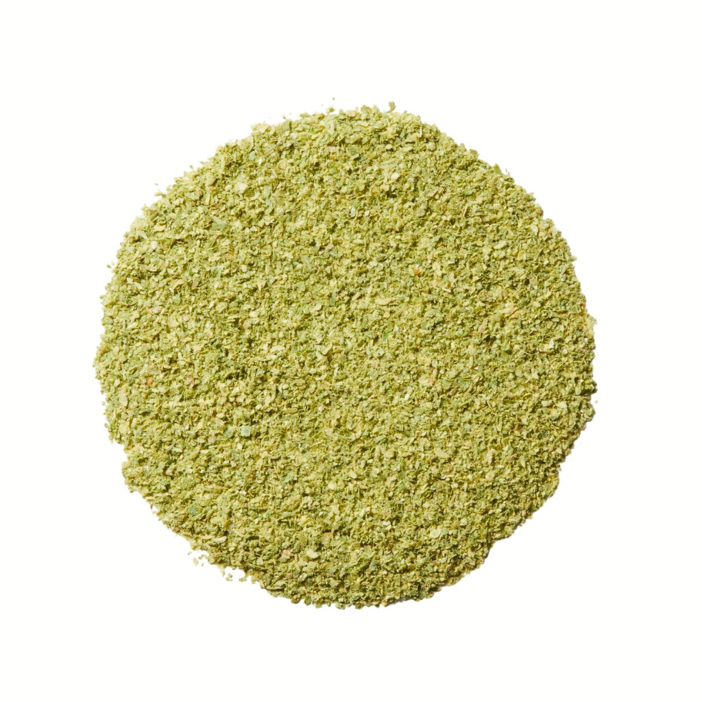 Round green spice blend on a white background